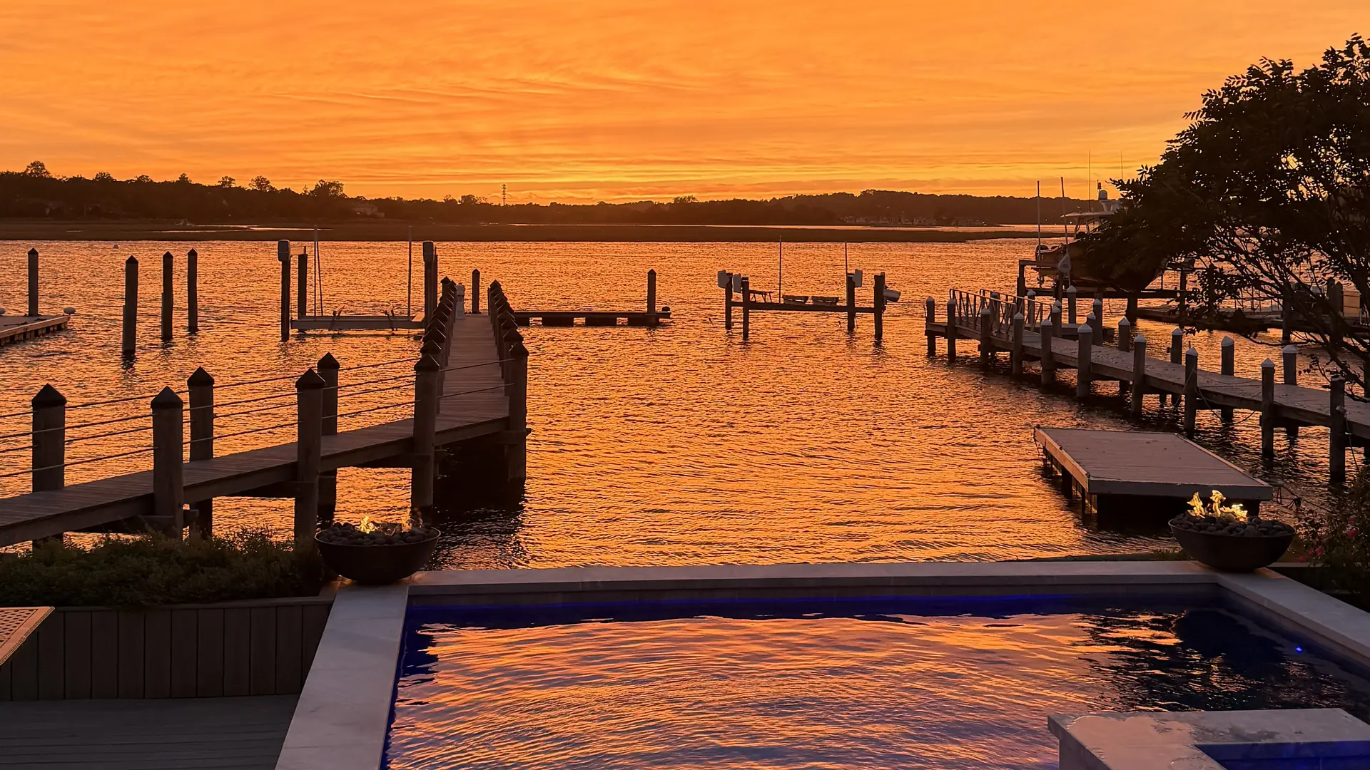 Custom pool and spa on the bay at sunset, designed and built by Artisan Landscapes and Pools